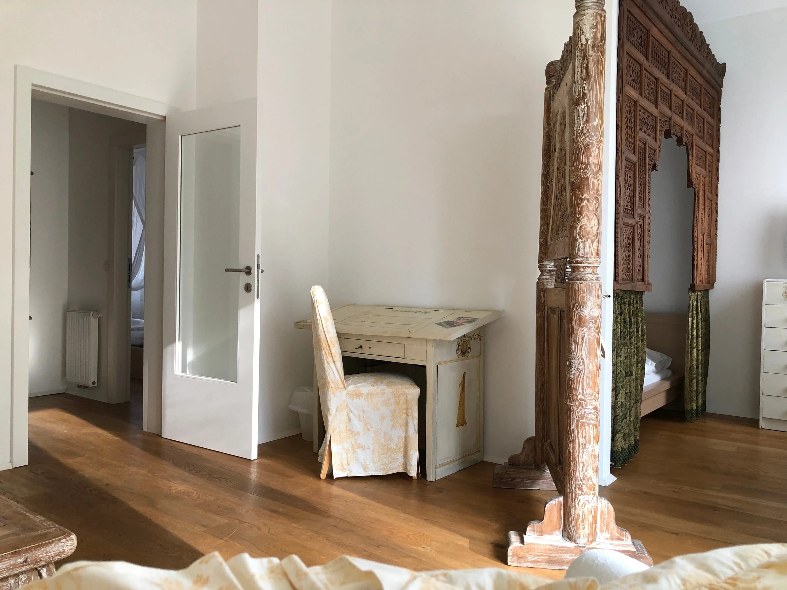 Aufenthaltsraum mit weißem Sofa, Holzbalken und geschnitzter Säule