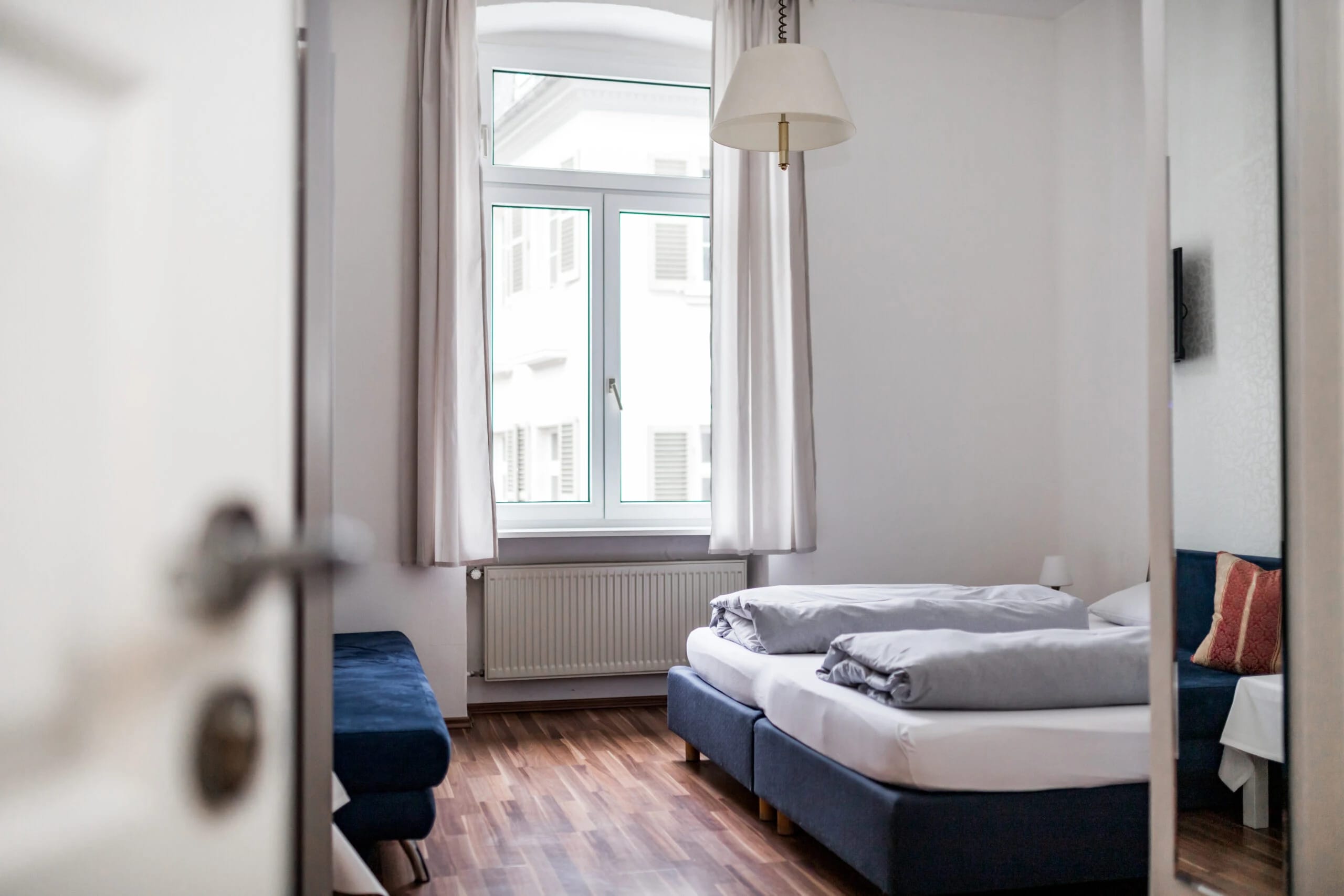 Helles Doppelzimmer mit Doppelbett und Fenster