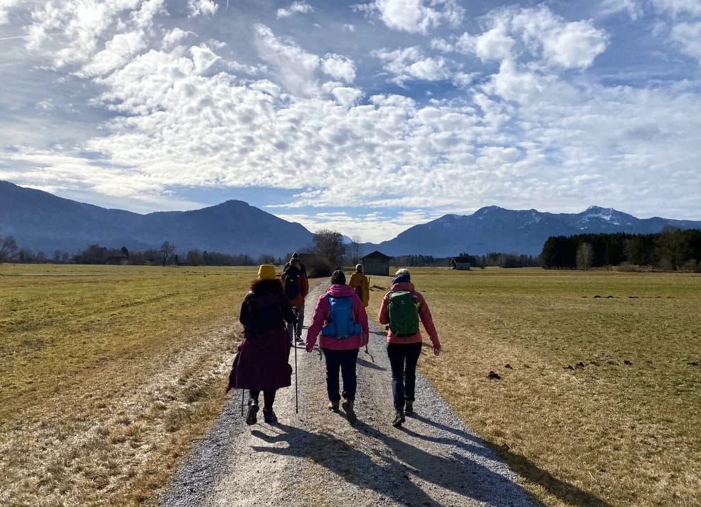 Wandergruppe auf einem Kiesweg vor der Bergkette im Isarwinkel