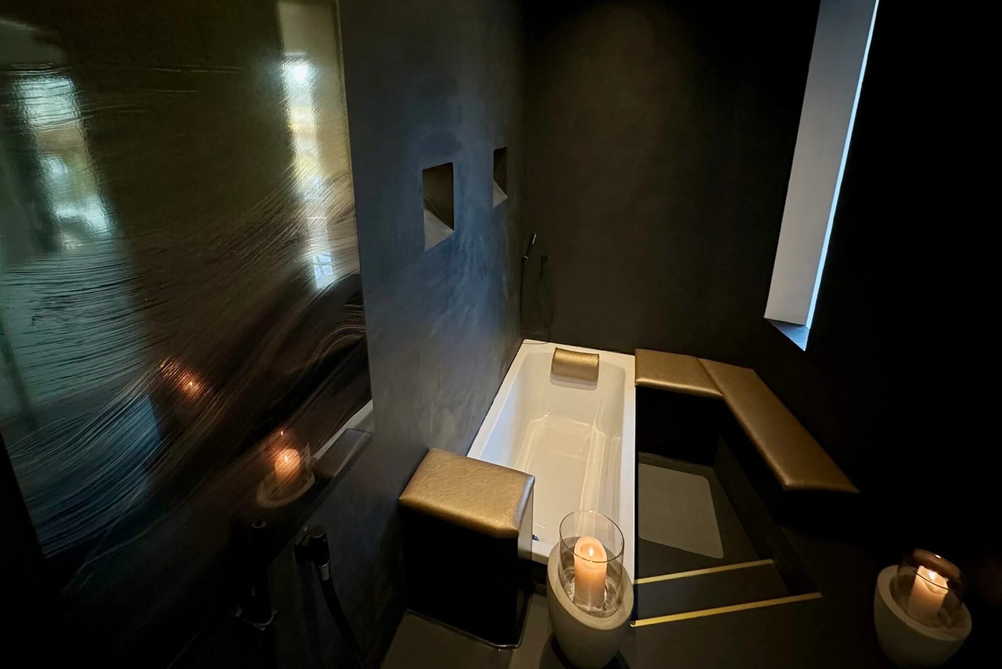 Wellnessbereich mit Badewanne und Kerzenlicht