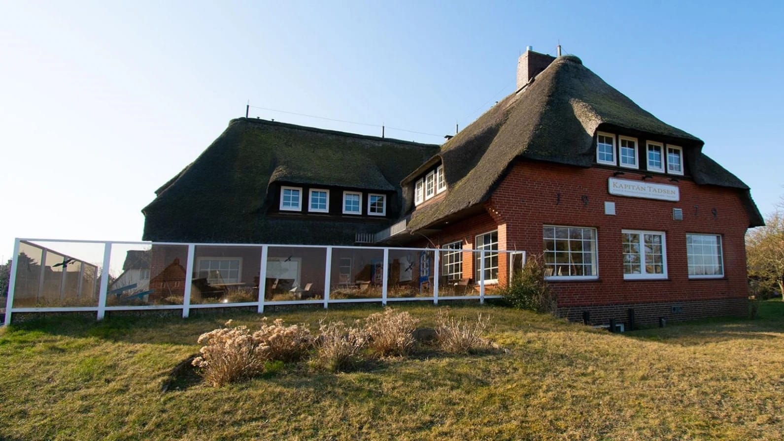 Reetdachhaus mit Rasenfläche als Unterkunft auf der Insel