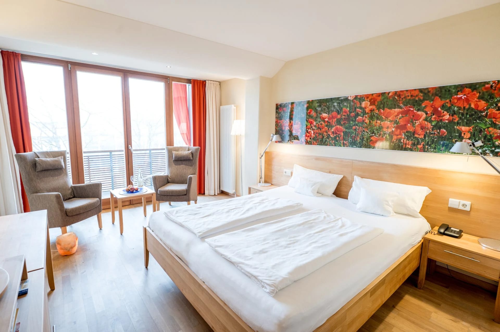 Juniorsuite mit Doppelbett, zwei Sesseln und großem Wandbild