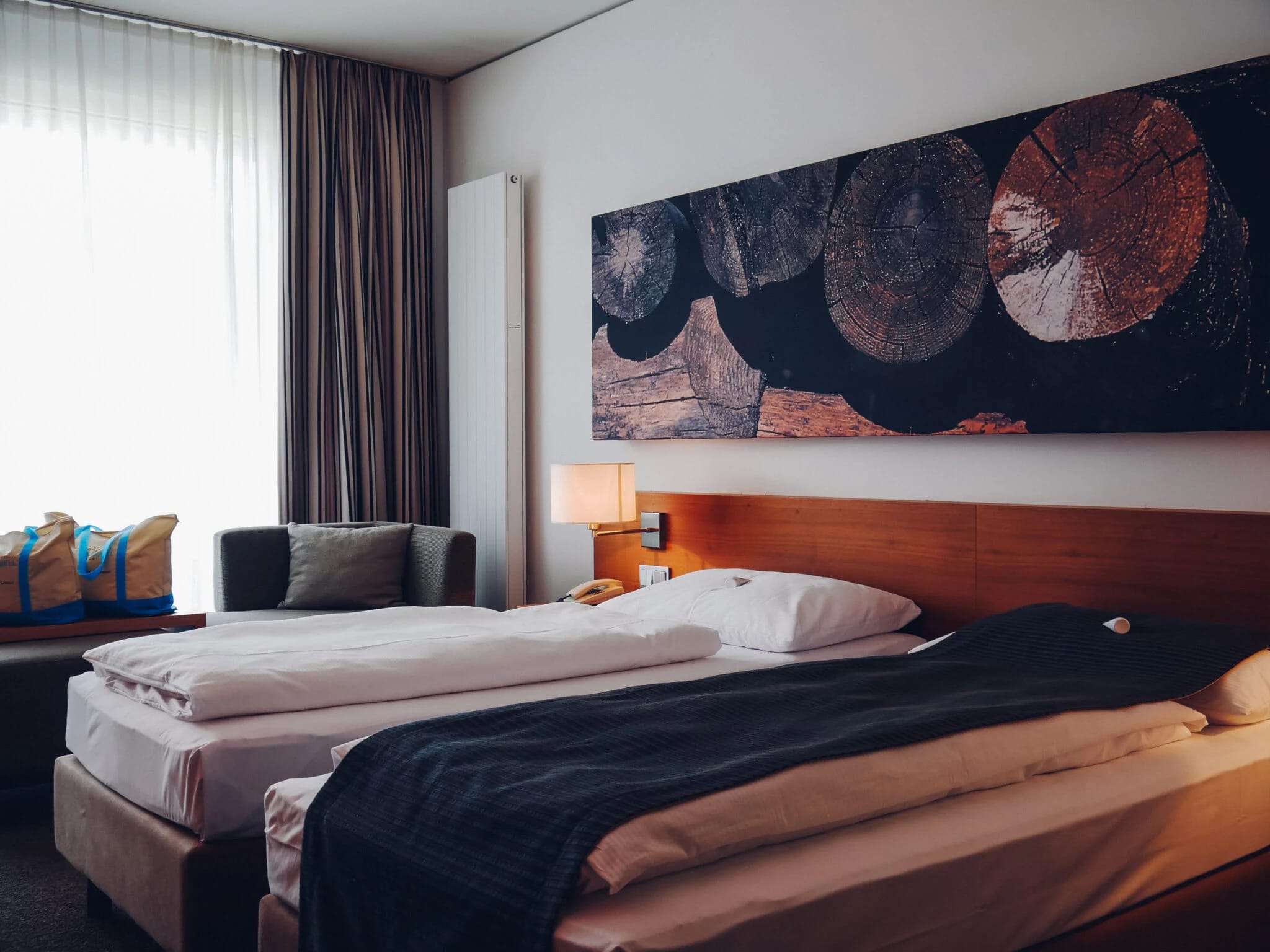 Juniorsuite mit Doppelbett, Sessel und großformatigem Wandbild über dem Bett