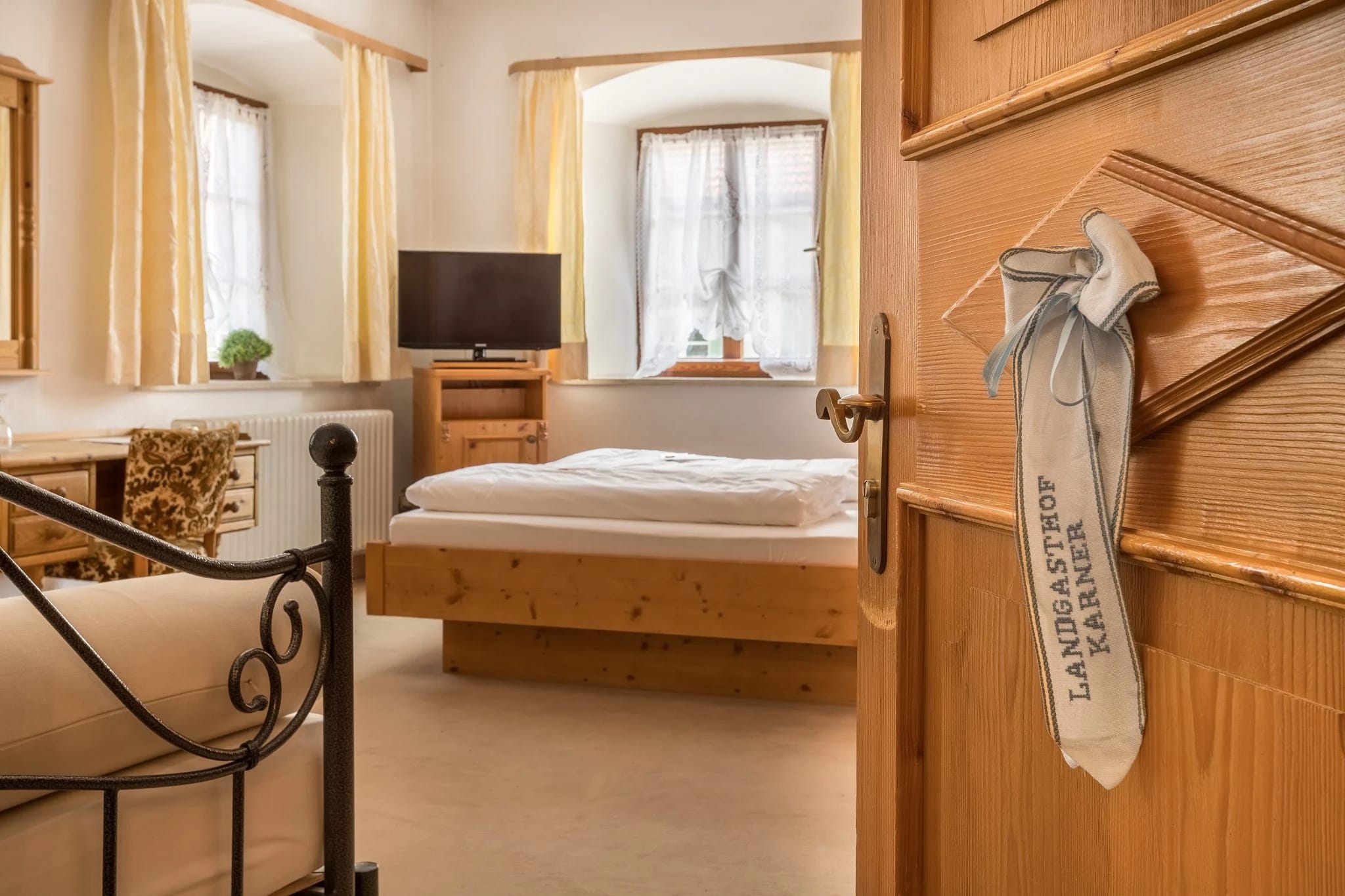 Geräumiges Zimmer mit floraler Tapete, Doppelbett und Sofa