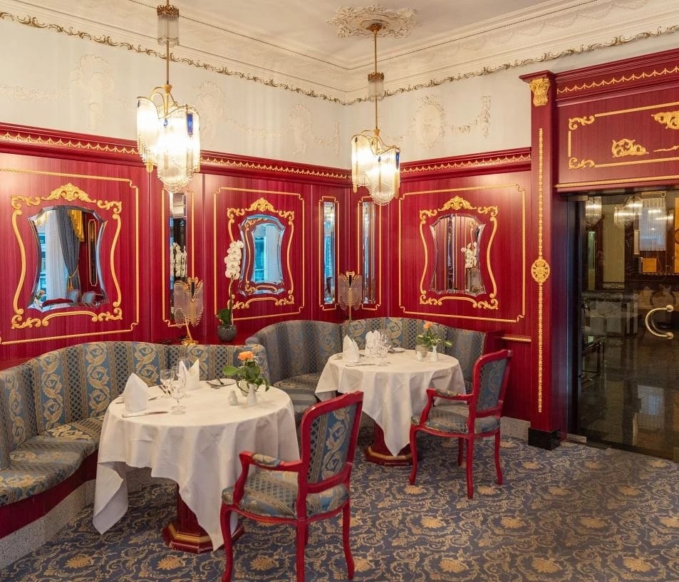 Intime Restaurantnische mit roten Wandpaneelen, Spiegeln und gepolsterter Sitzbank