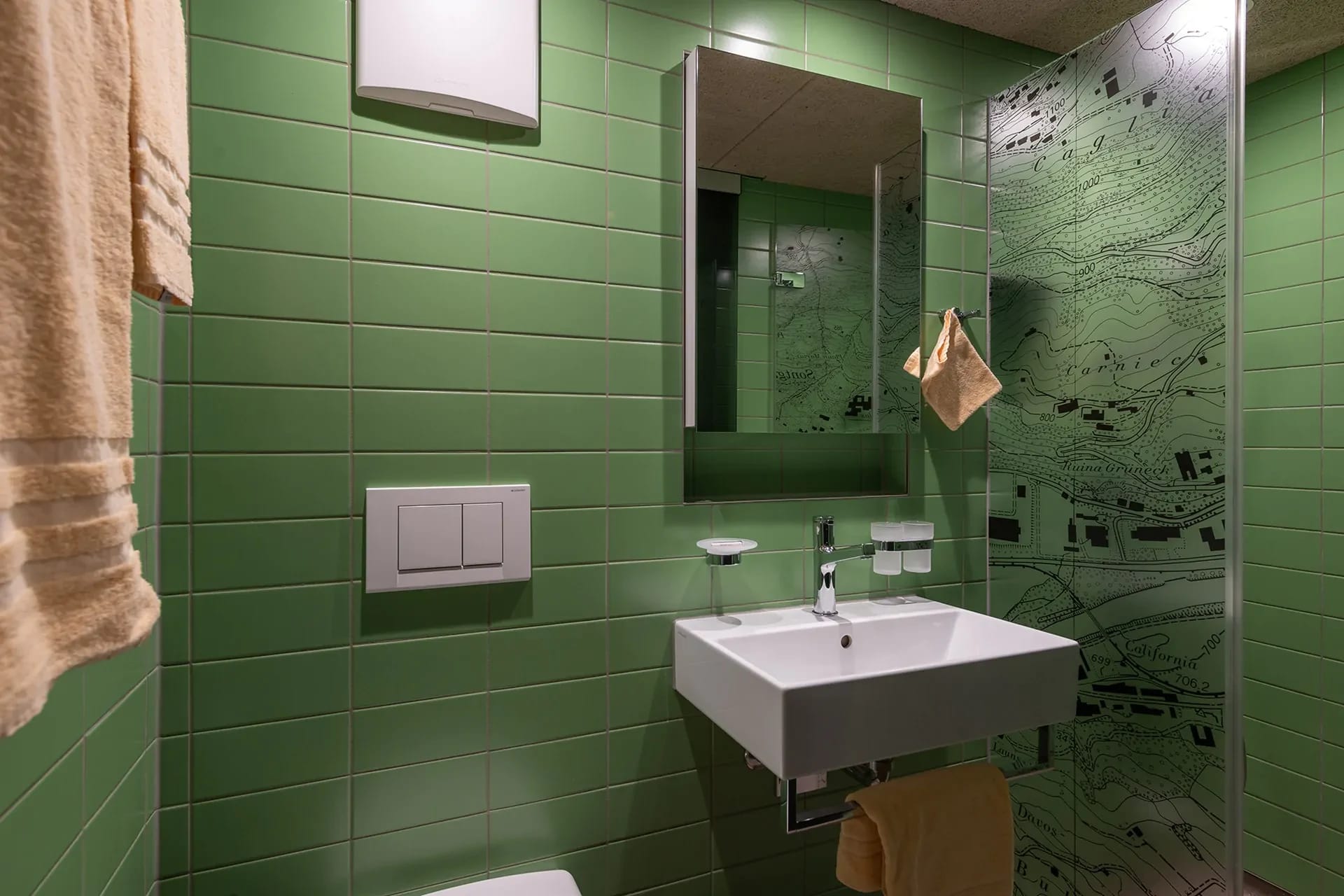 Badezimmer mit grünen Wandfliesen, Waschbecken und Spiegelschrank