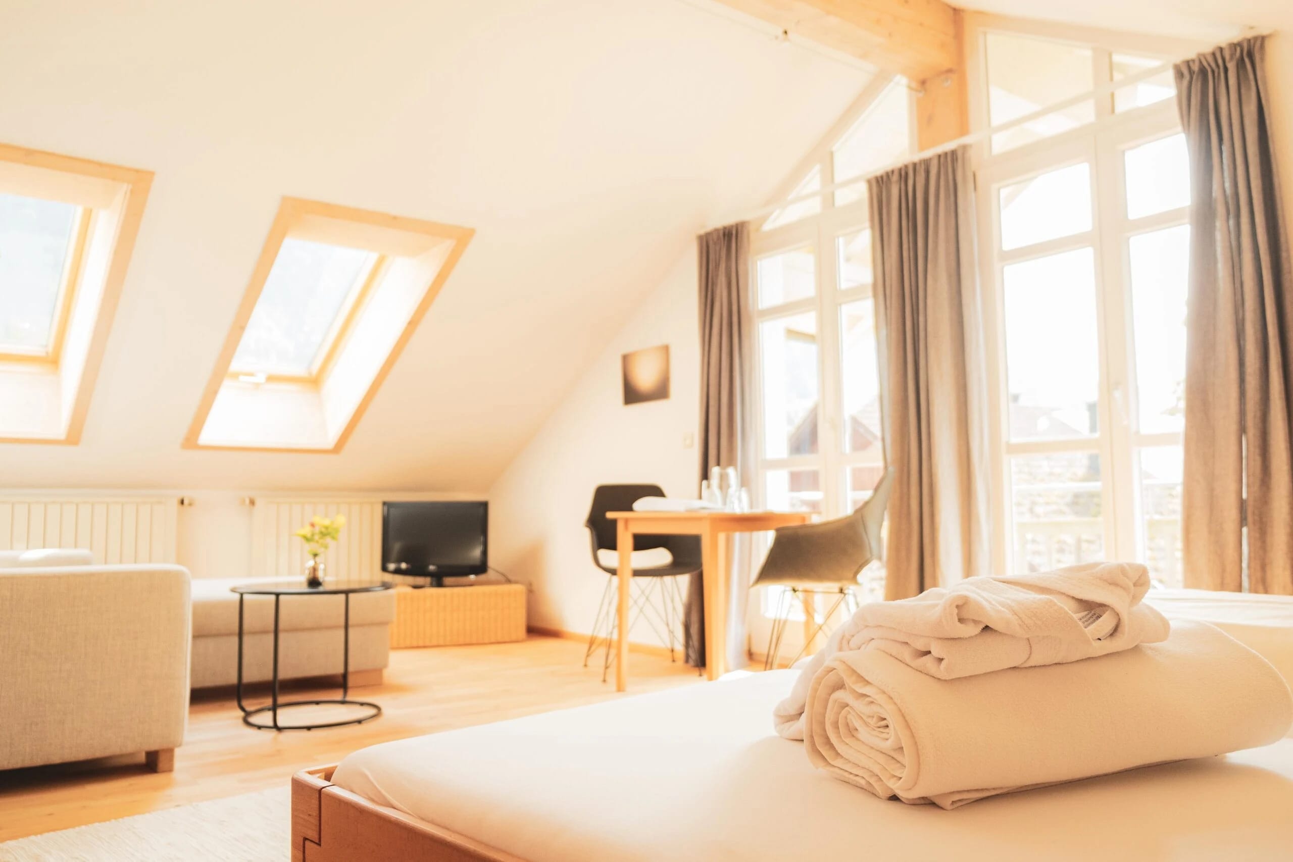 Helles Dachgeschoss-Apartment mit großen Fenstern und Sitzbereich