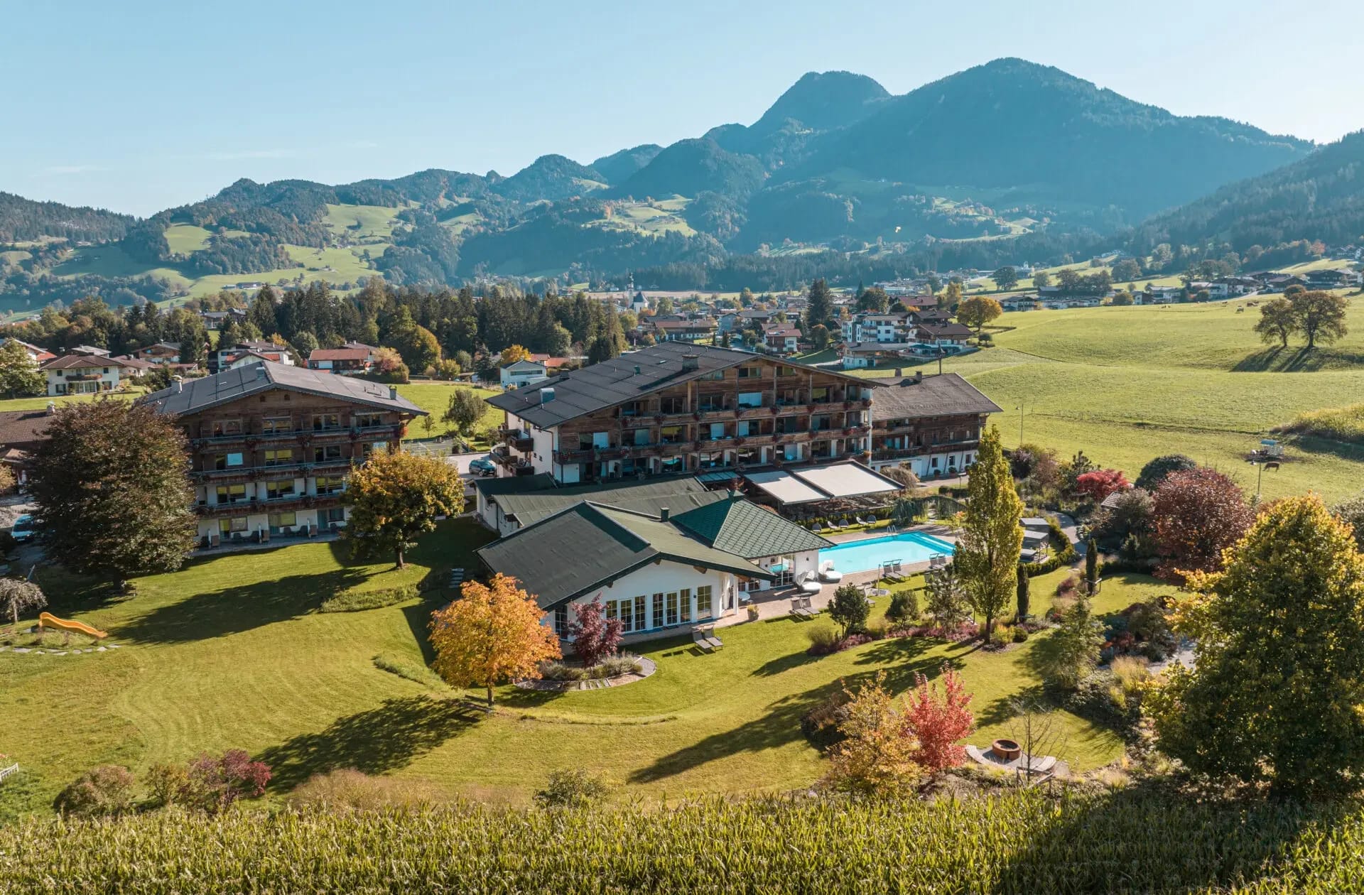 Luftaufnahme des Hotel Pirchnerhof im Herbst mit Außenpool und umliegender Landschaft im Alpbachtal