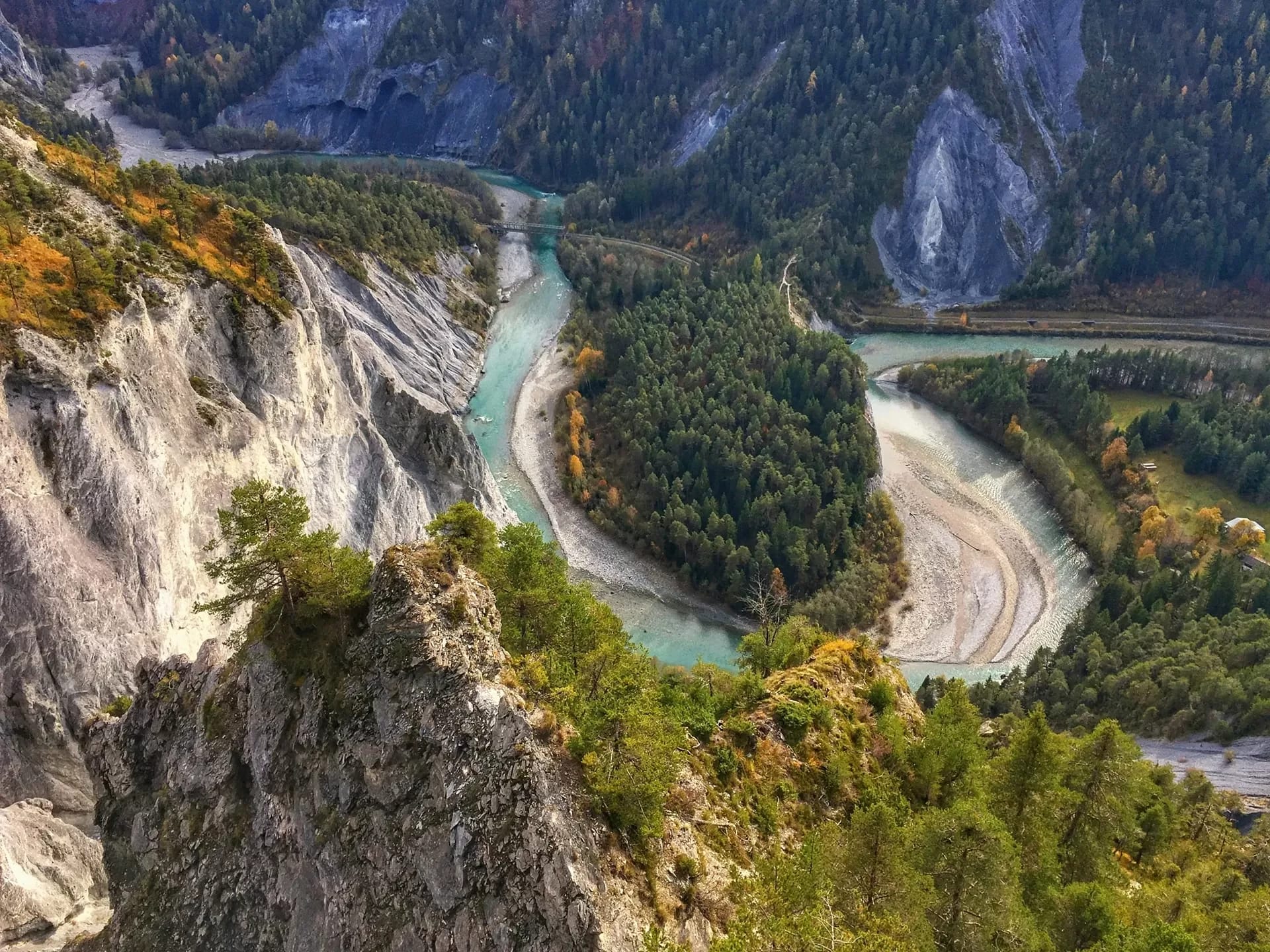 Blick in die Rheinschlucht mit türkisfarbenem Fluss zwischen bewaldeten Felswänden