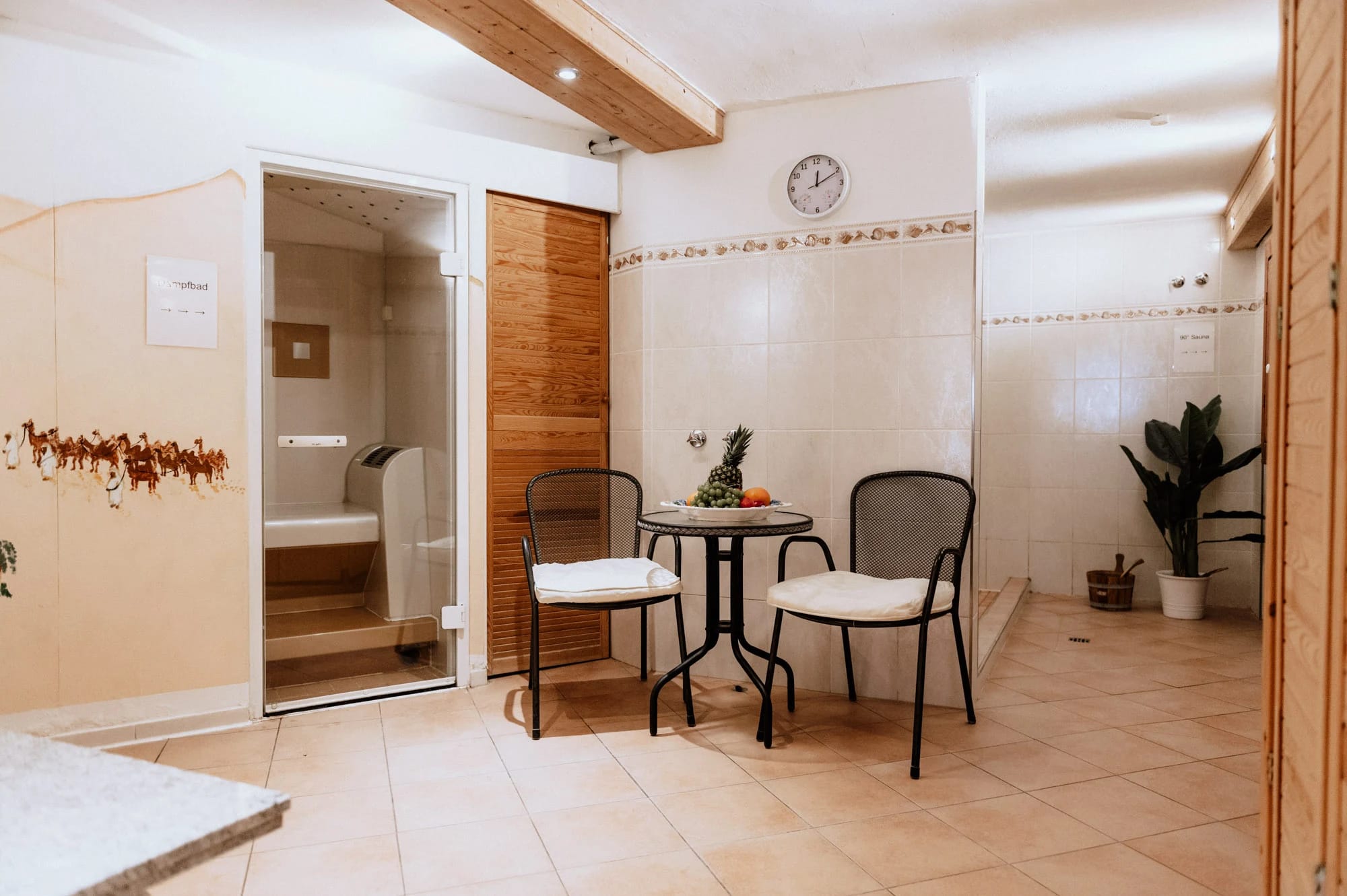 Saunabereich mit Sitzecke und Glastür zur Sauna