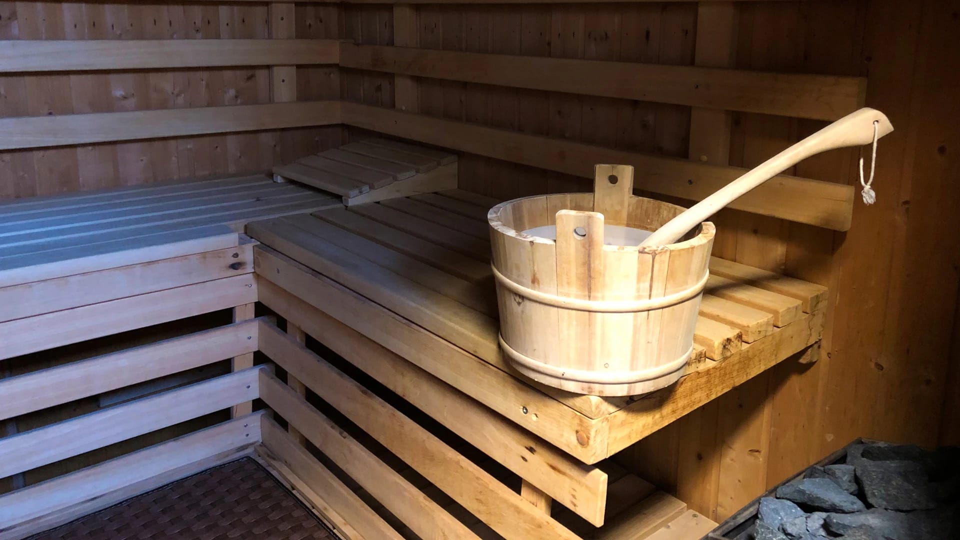 Finnische Sauna mit Holzbänken und Aufgusskübel