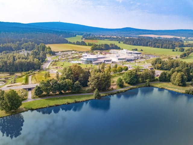Luftaufnahme des Resorts oberhalb des Weißenstädter Sees, umgeben von Wald und Wiesen