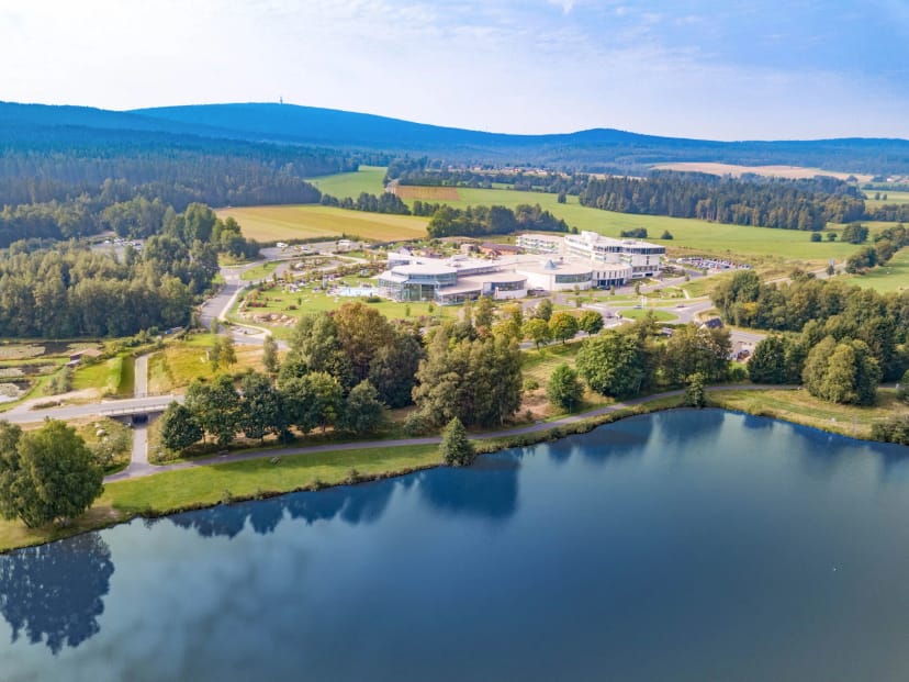 Luftaufnahme des Resorts oberhalb des Weißenstädter Sees, umgeben von Wald und Wiesen