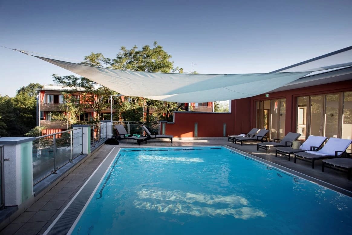 Thermal-Außenpool mit Sonnensegeln und Liegestühlen auf der Dachterrasse
