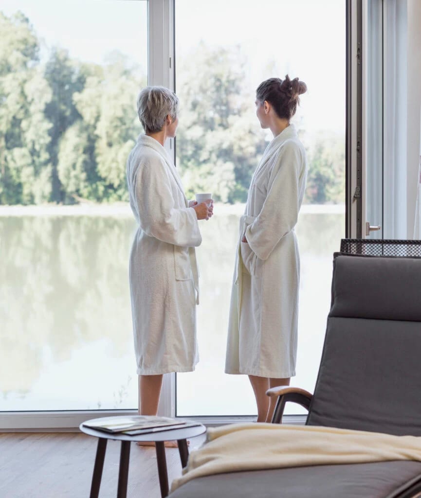 Ruheraum mit Relaxliege und bodentiefem Fenster mit Blick auf Fluss und Bäume