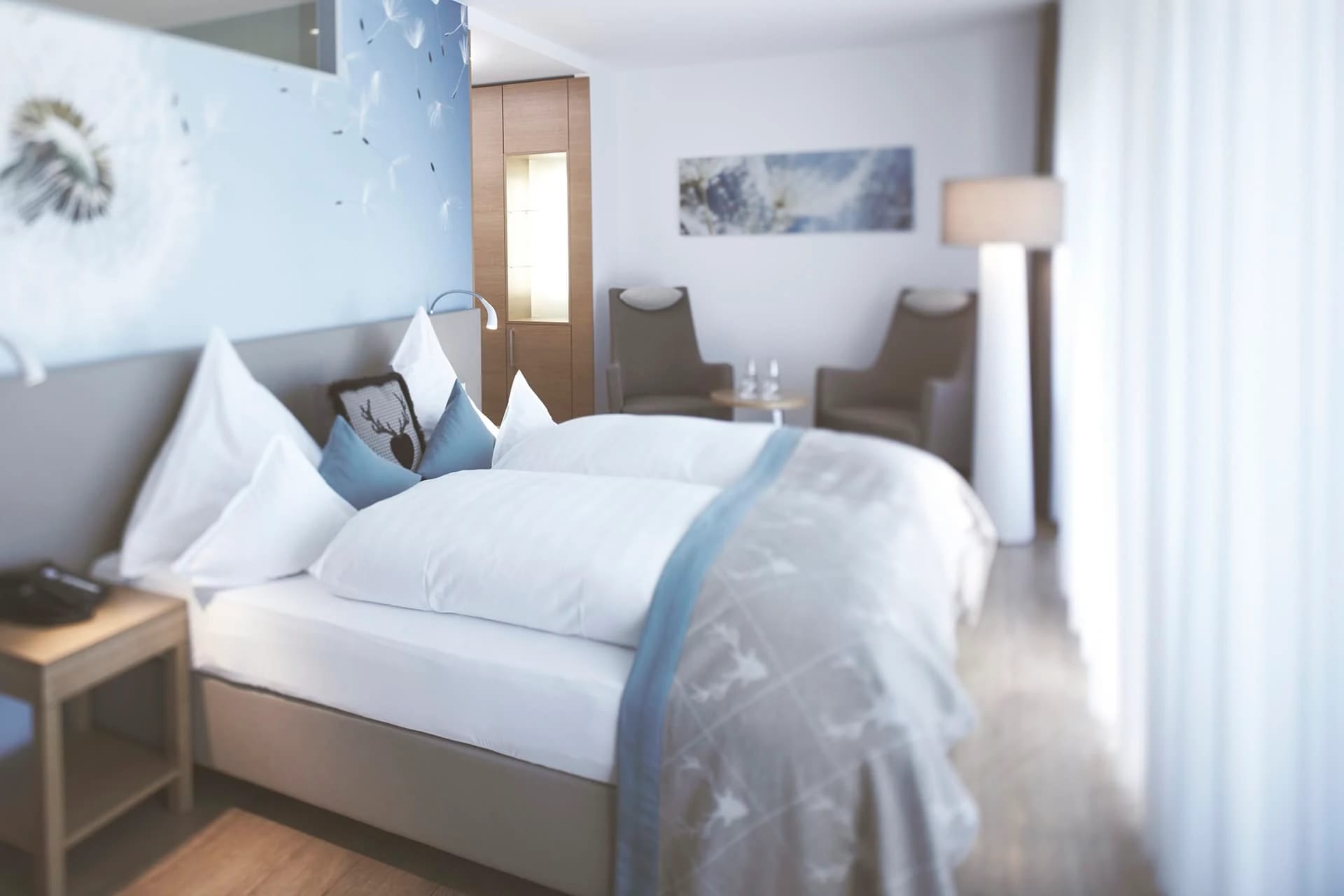 Doppelzimmer mit Pusteblumen-Wandbild in Blautönen