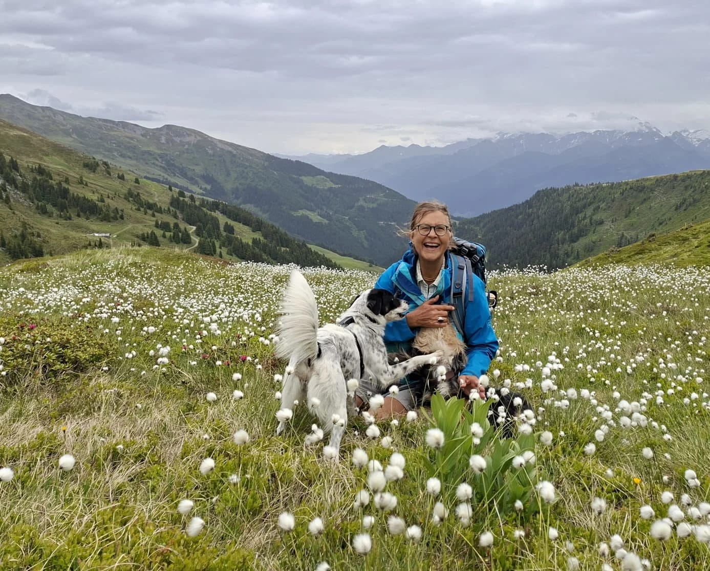 Christine Fegerl mit ihren zwei Hunden auf einer Bergwiese mit Wollgras