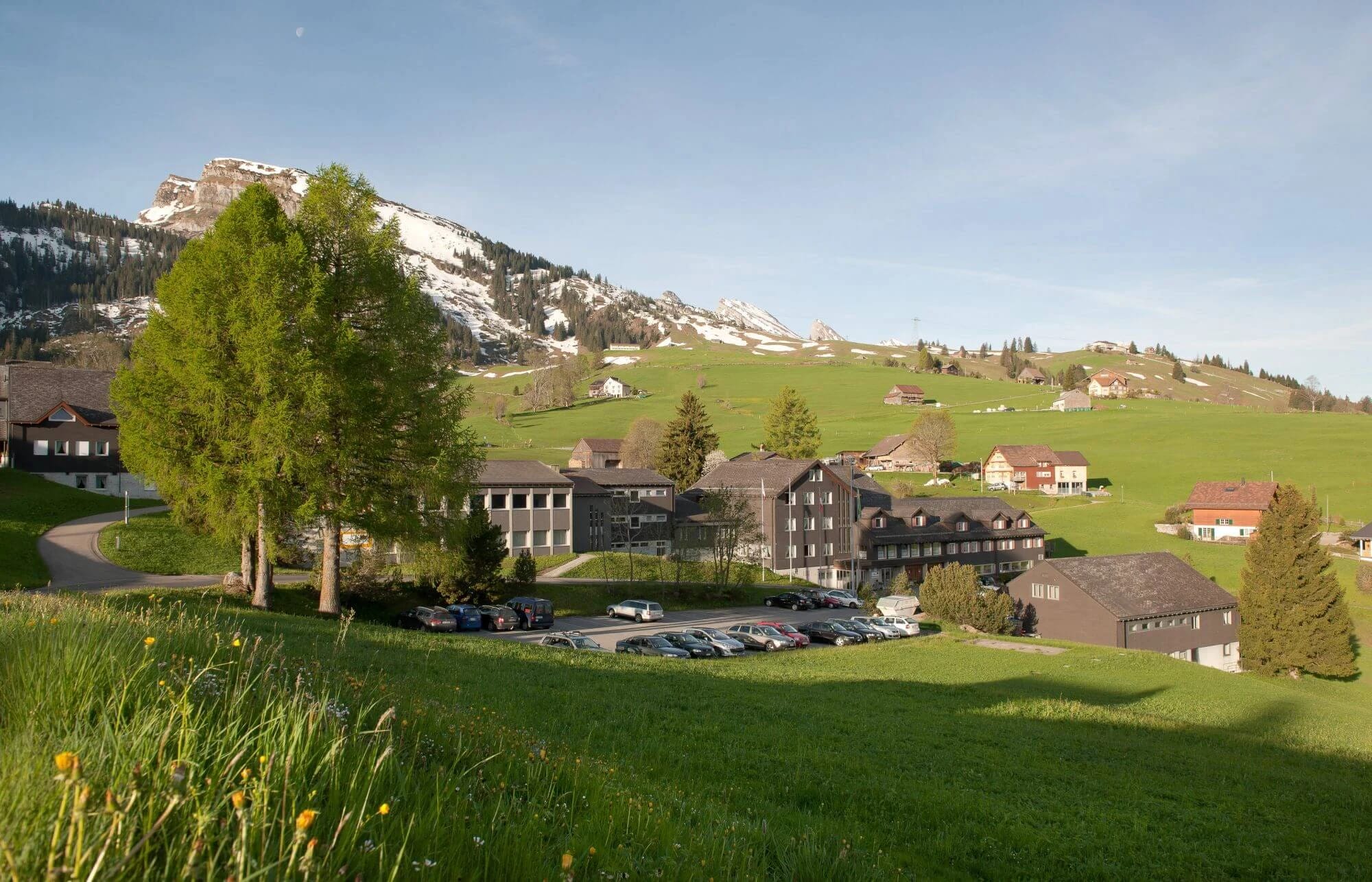 Luftaufnahme des Fasten-Retreat-Hauses in Wildhaus vor Bergpanorama