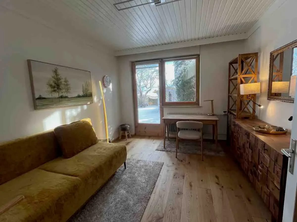 Wohnzimmer im Gartenloft mit gelbem Sofa und Holzboden