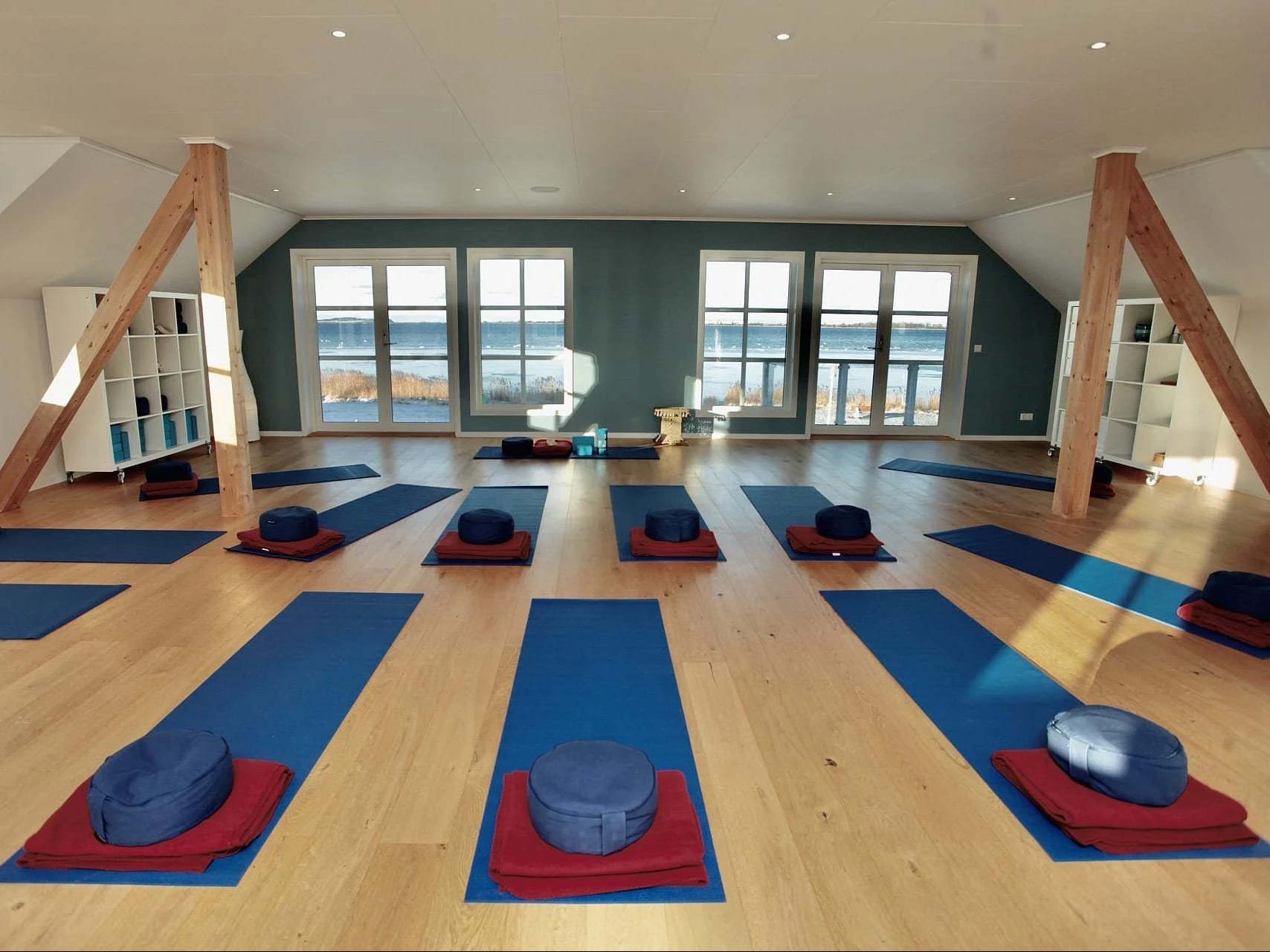 Yogaraum mit Matten und Meditationskissen und Meerblick