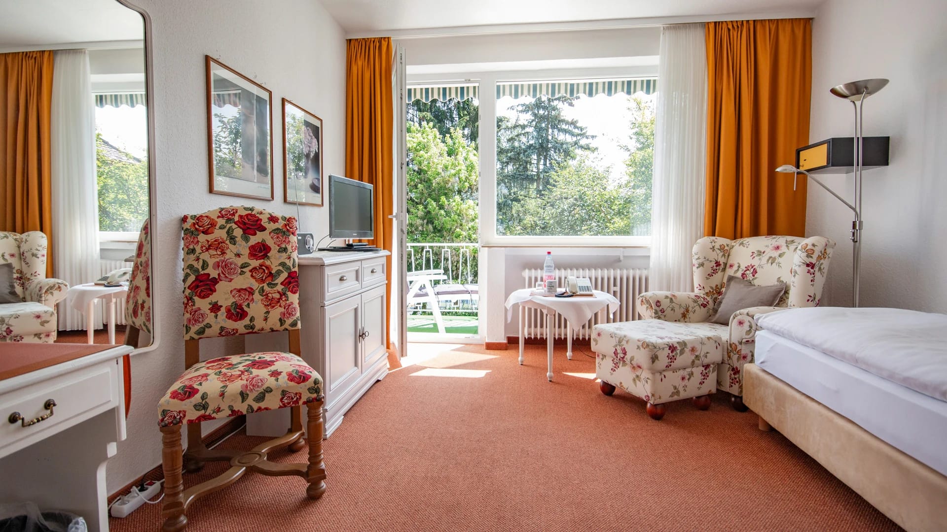 Zimmer mit Sitzecke und Balkontür zum Grünen