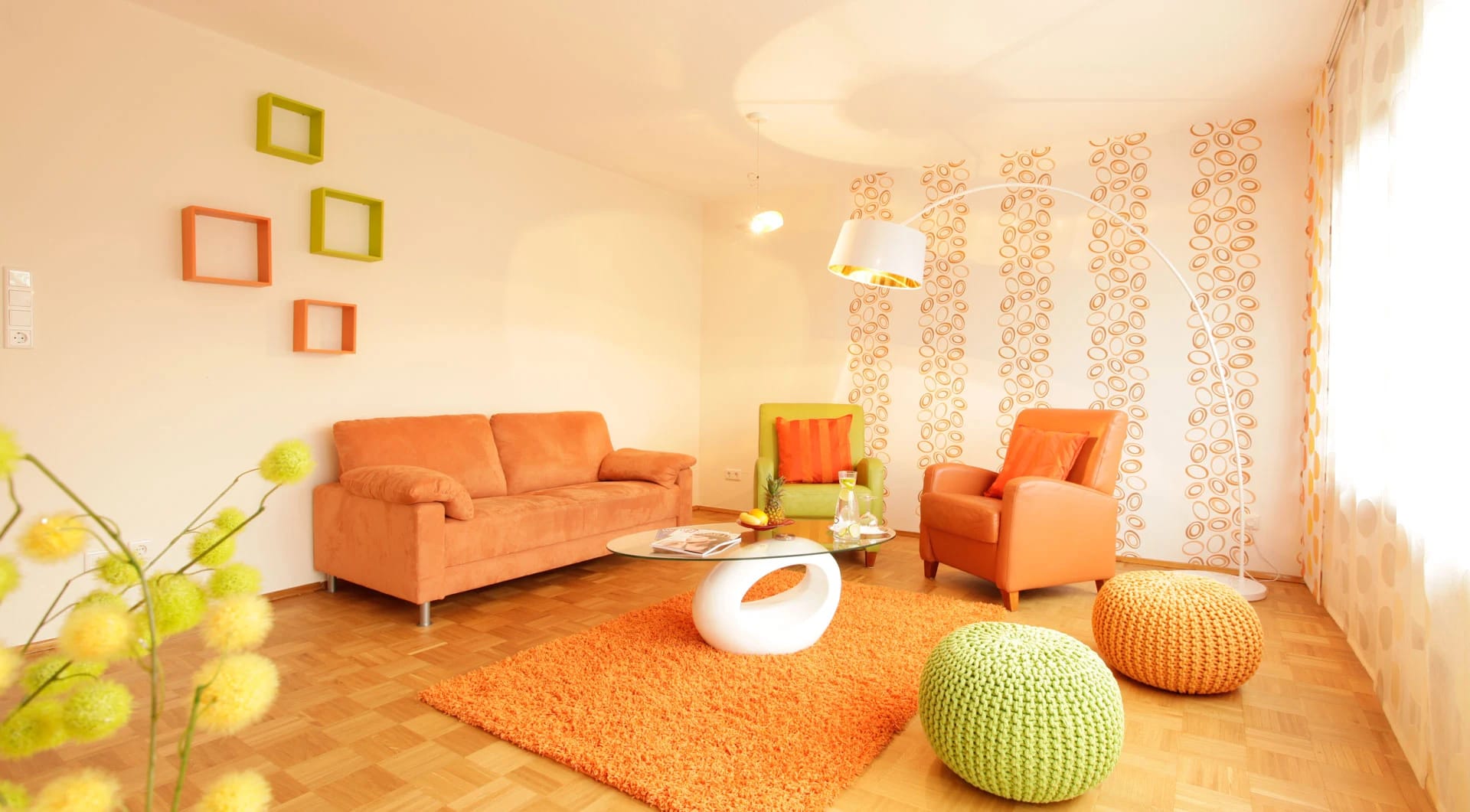 Wohnraum im Retro-Stil mit orangefarbenem Sofa, Sessel und Hochflorteppich