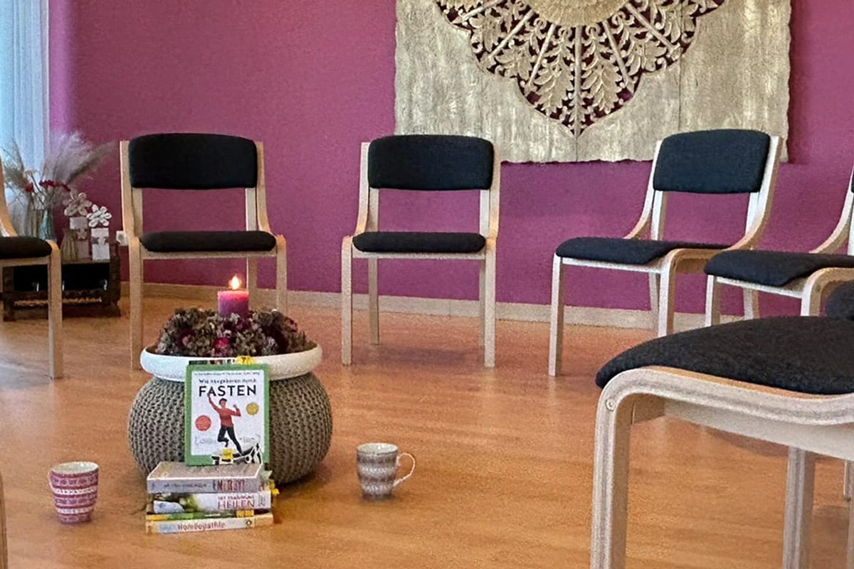 Seminarraum mit Stuhlkreis, Kerzen und Büchern zum Thema Fasten