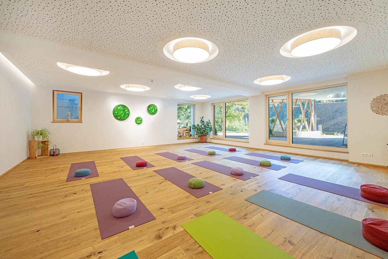 Heller Yogaraum mit Matten und Meditationskissen