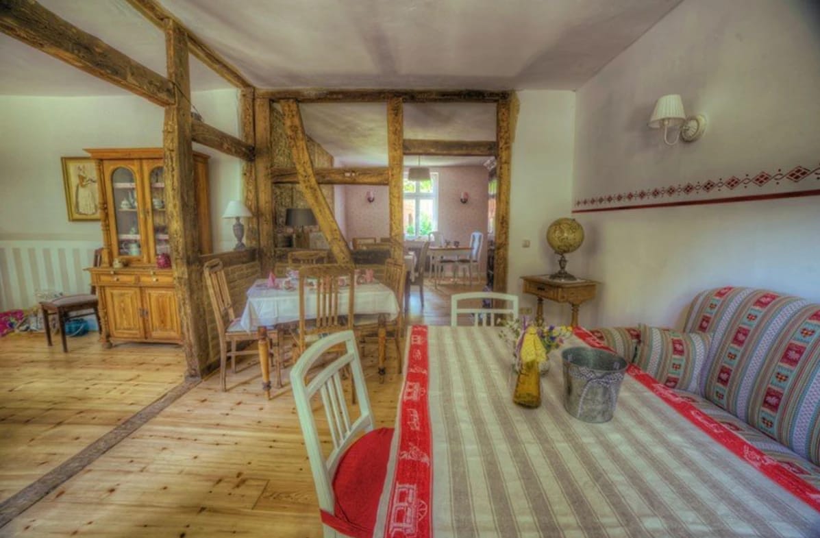 Rustikaler Speisesaal mit gedeckten Tischen und Fachwerkbalken