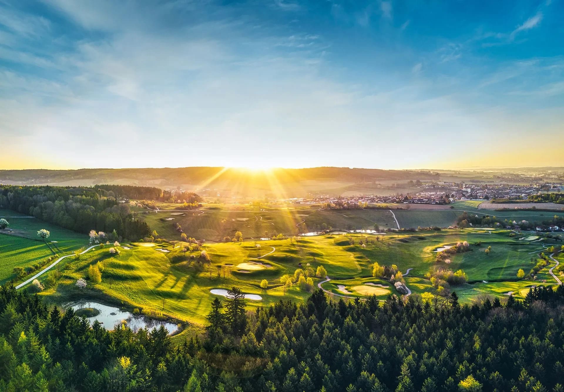 Golfpark in hügeliger Landschaft bei Bad Birnbach aus der Luft im Morgenlicht