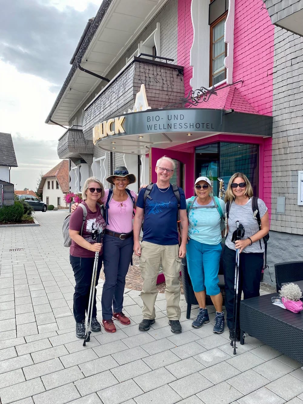 Fastenwandergruppe mit Wanderstöcken vor einem Bio- und Wellnesshotel