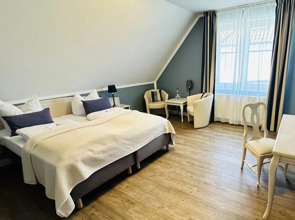 Helles Zimmer mit Doppelbett unter Dachschräge und Fenster