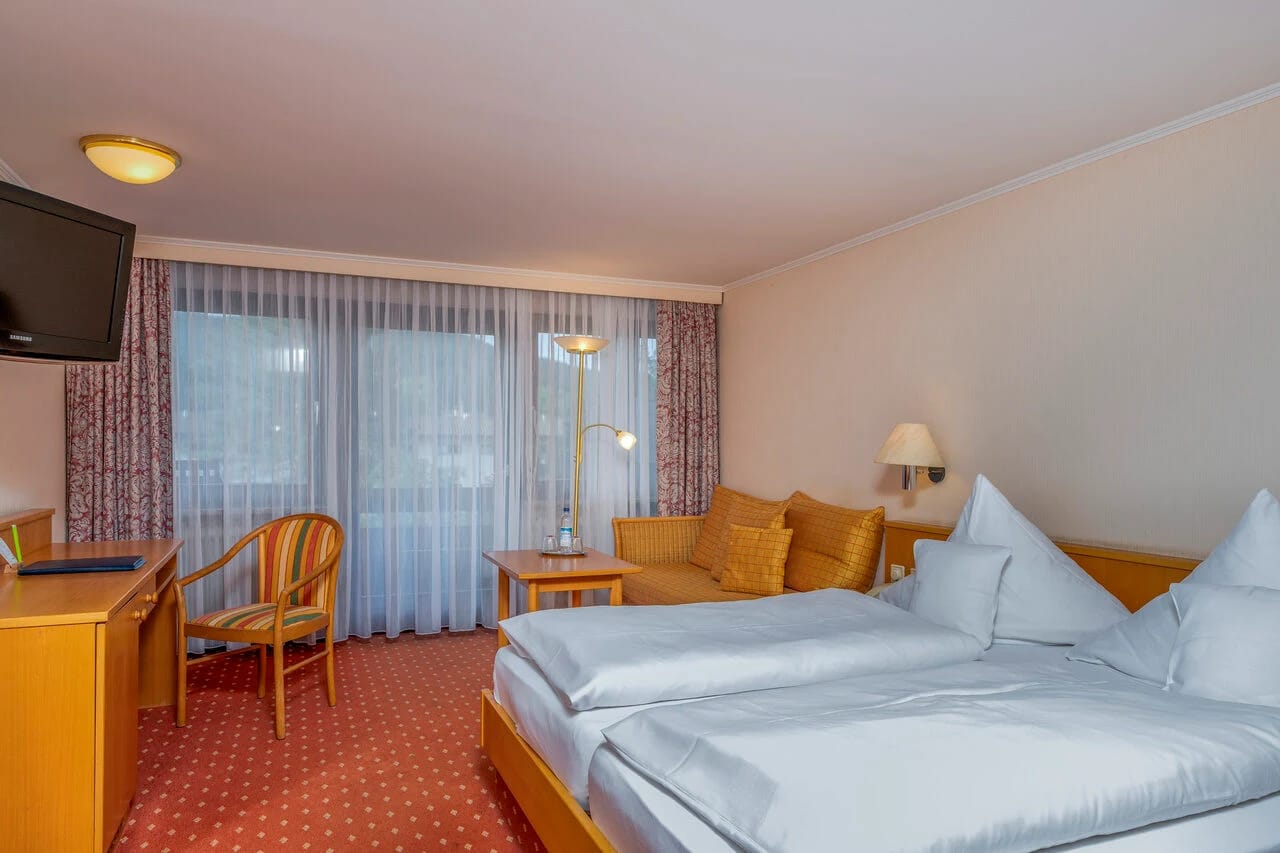 Doppelzimmer mit Doppelbett, Sitzecke und Fernseher