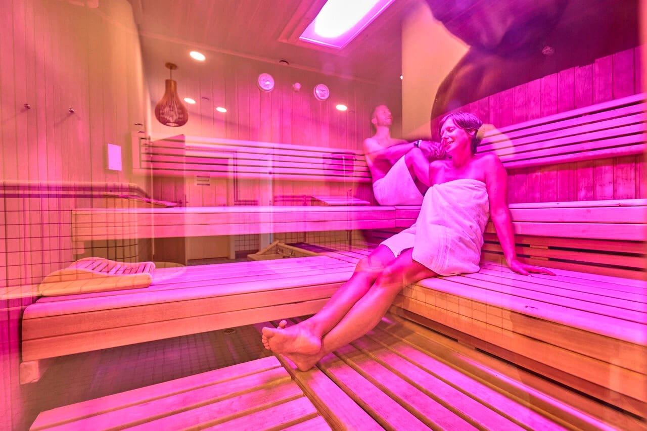 Finnische Sauna aus Holz mit Glastür zum Außenbereich