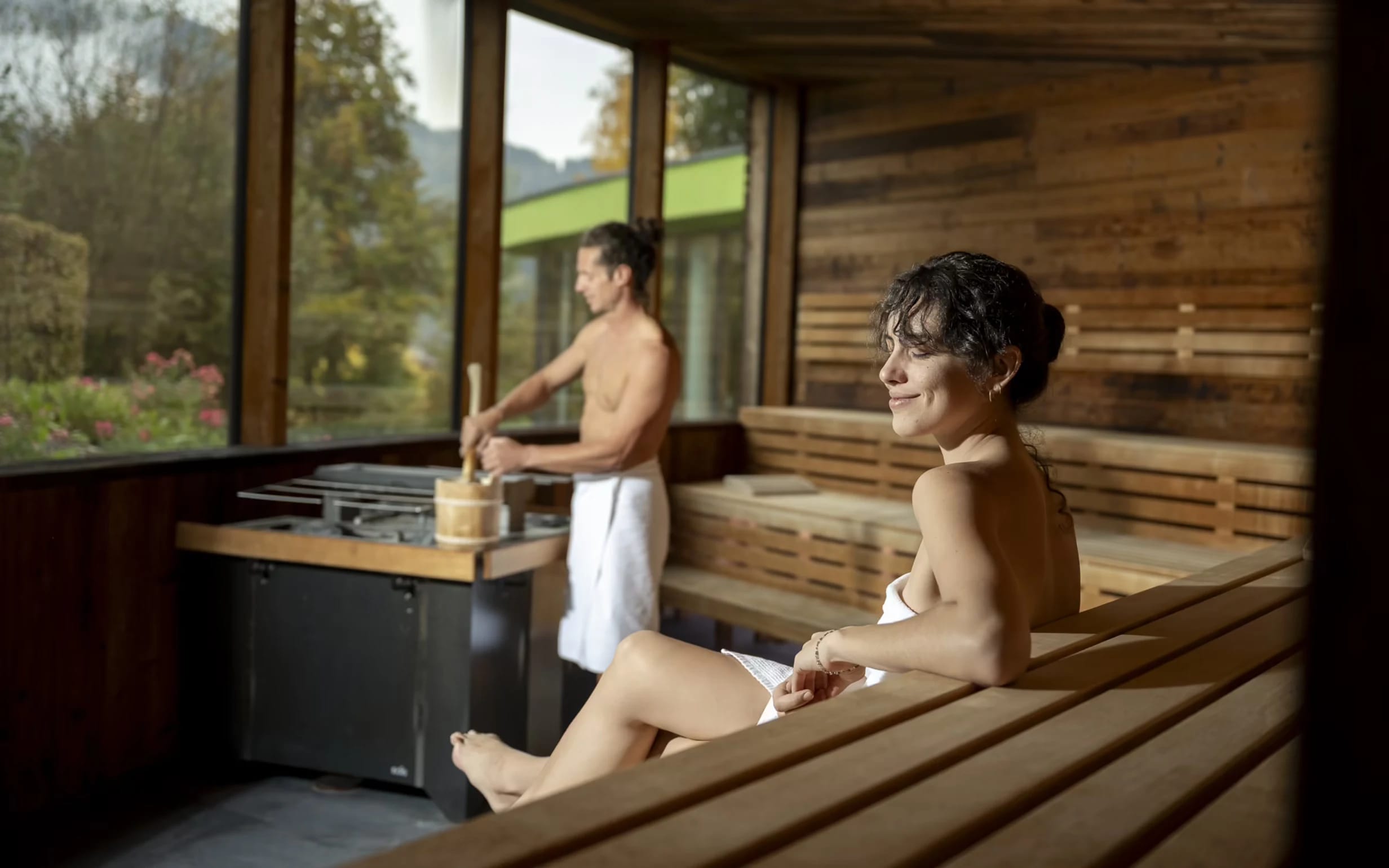 Geräumige Holzsauna mit Panoramafenster und Blick ins Grüne