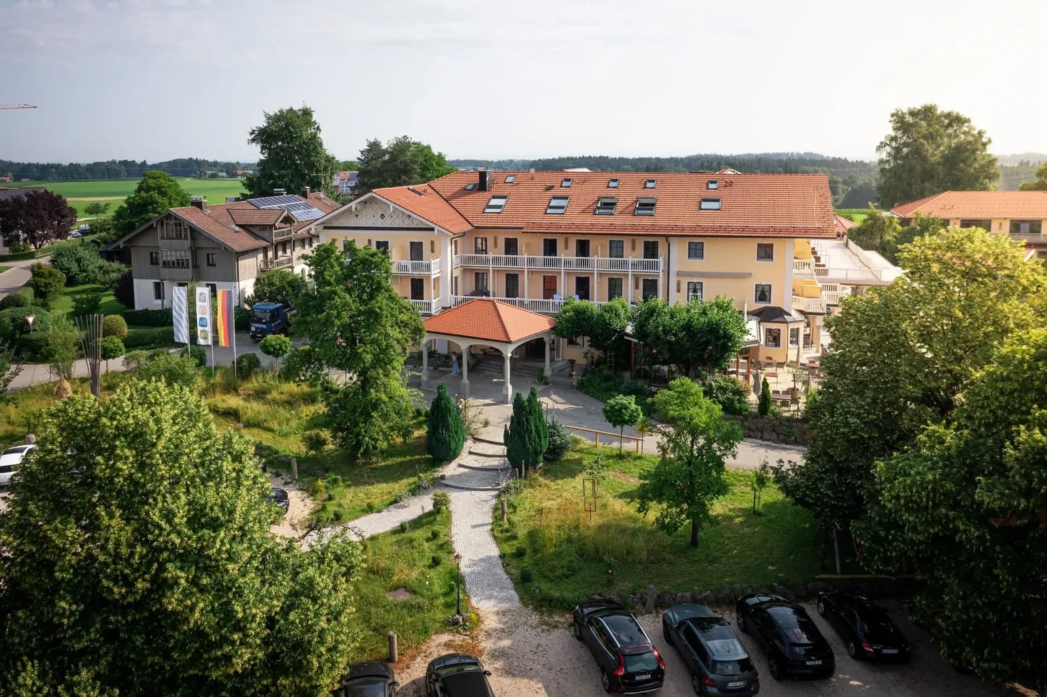 Luftaufnahme des Hotelgebäudes mit Garten und Pavillon im Sommer