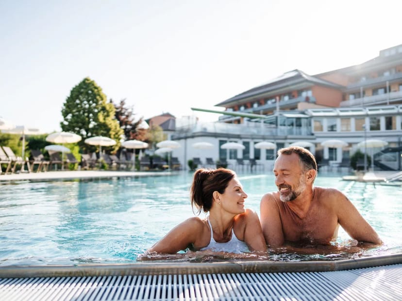 Außenpool mit Sonnenschirmen und dem Hotelgebäude im Hintergrund