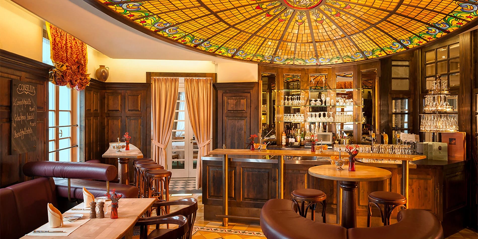 Bar Belle Epoque mit bunter Glaskuppel und Holzeinrichtung