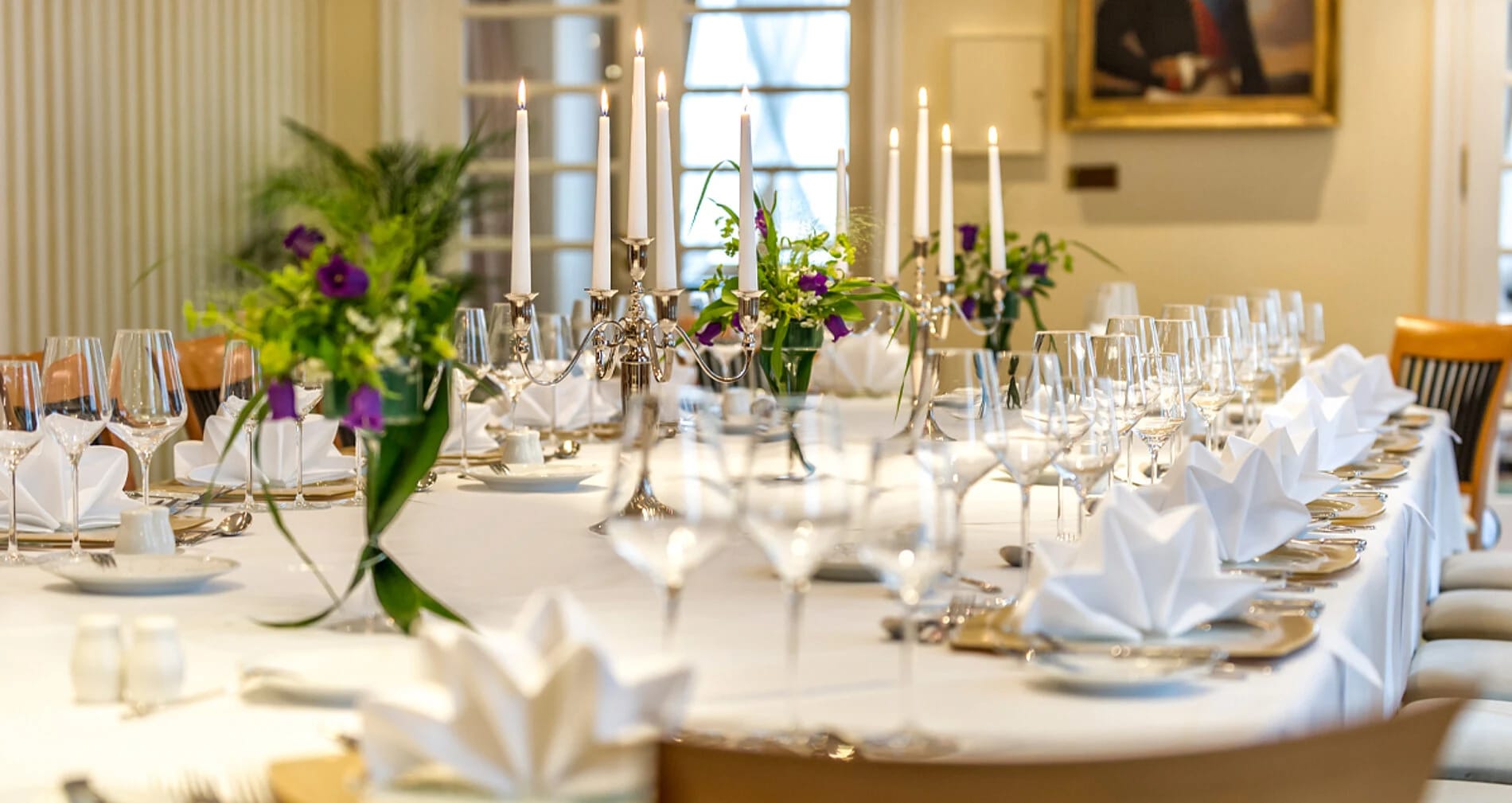 Festlich eingedeckte Tafel mit Kerzenleuchtern und Blumenschmuck