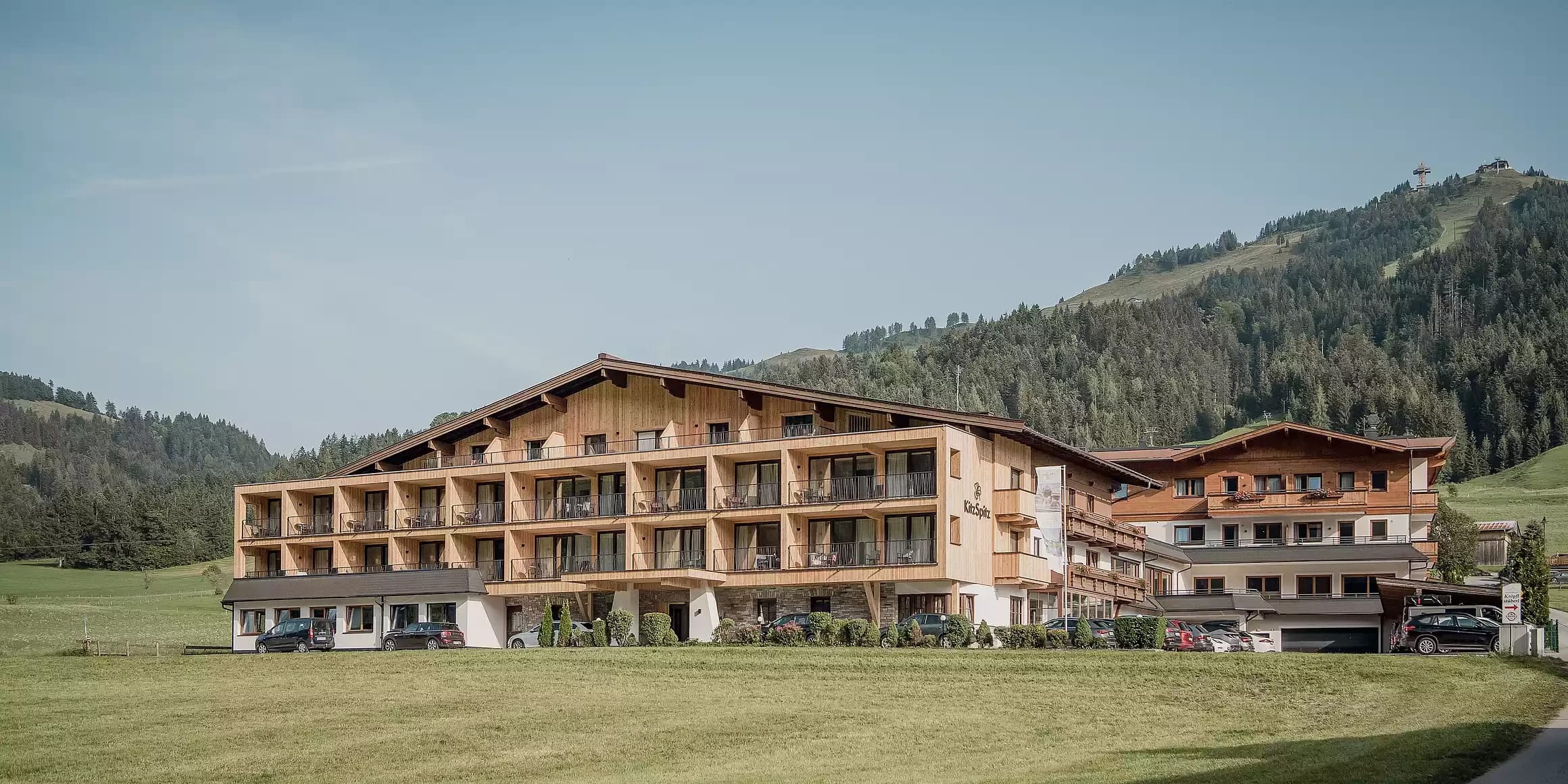 Außenansicht des Naturhotels Kitzspitz im Sommer vor Bergkulisse