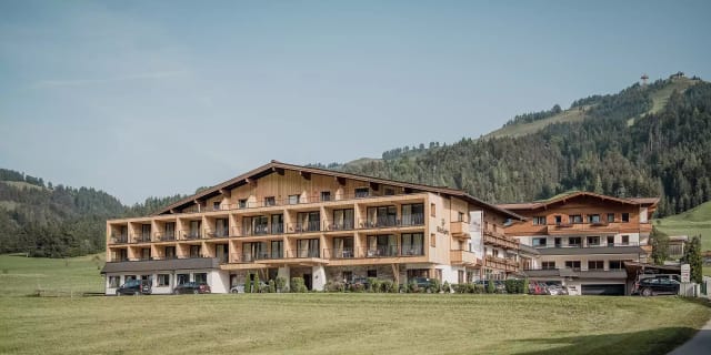 Außenansicht des Naturhotels Kitzspitz im Sommer vor Bergkulisse