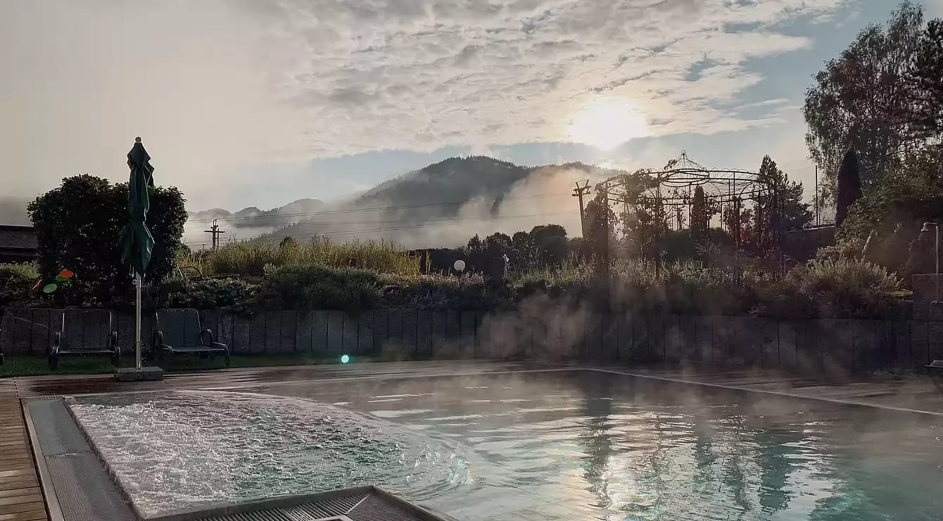 Außenpool am Morgen mit Nebel über den Bergen