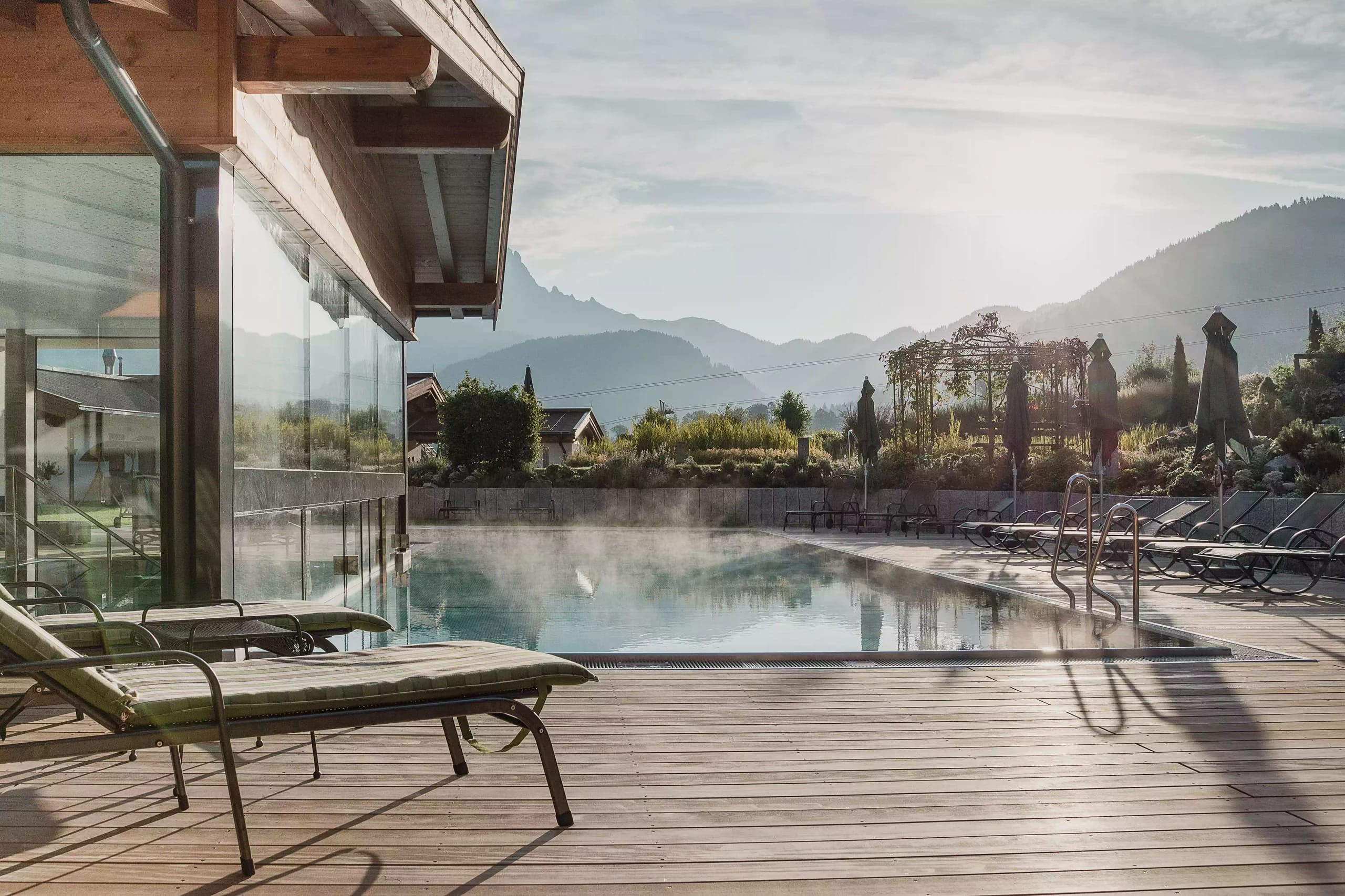 Sonnenterrasse aus Holz mit Außenpool, Liege und Bergblick