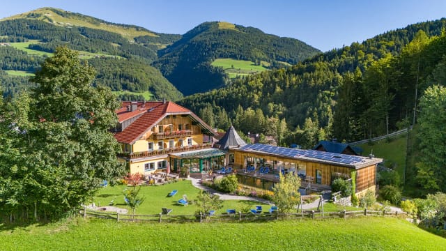 Luftaufnahme des Biohotels Sommerau, eingebettet in Wiesen und bewaldete Berge