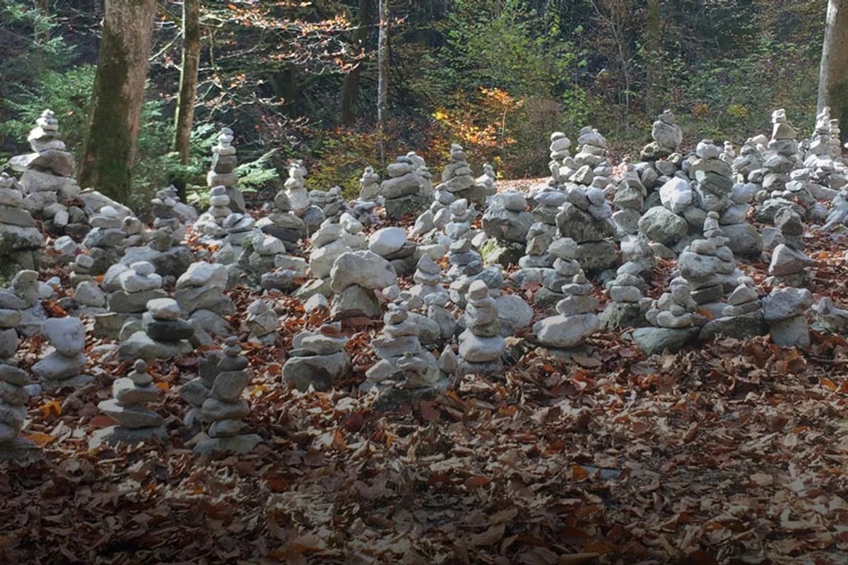 Kleine Steintürme auf herbstlichem Waldboden