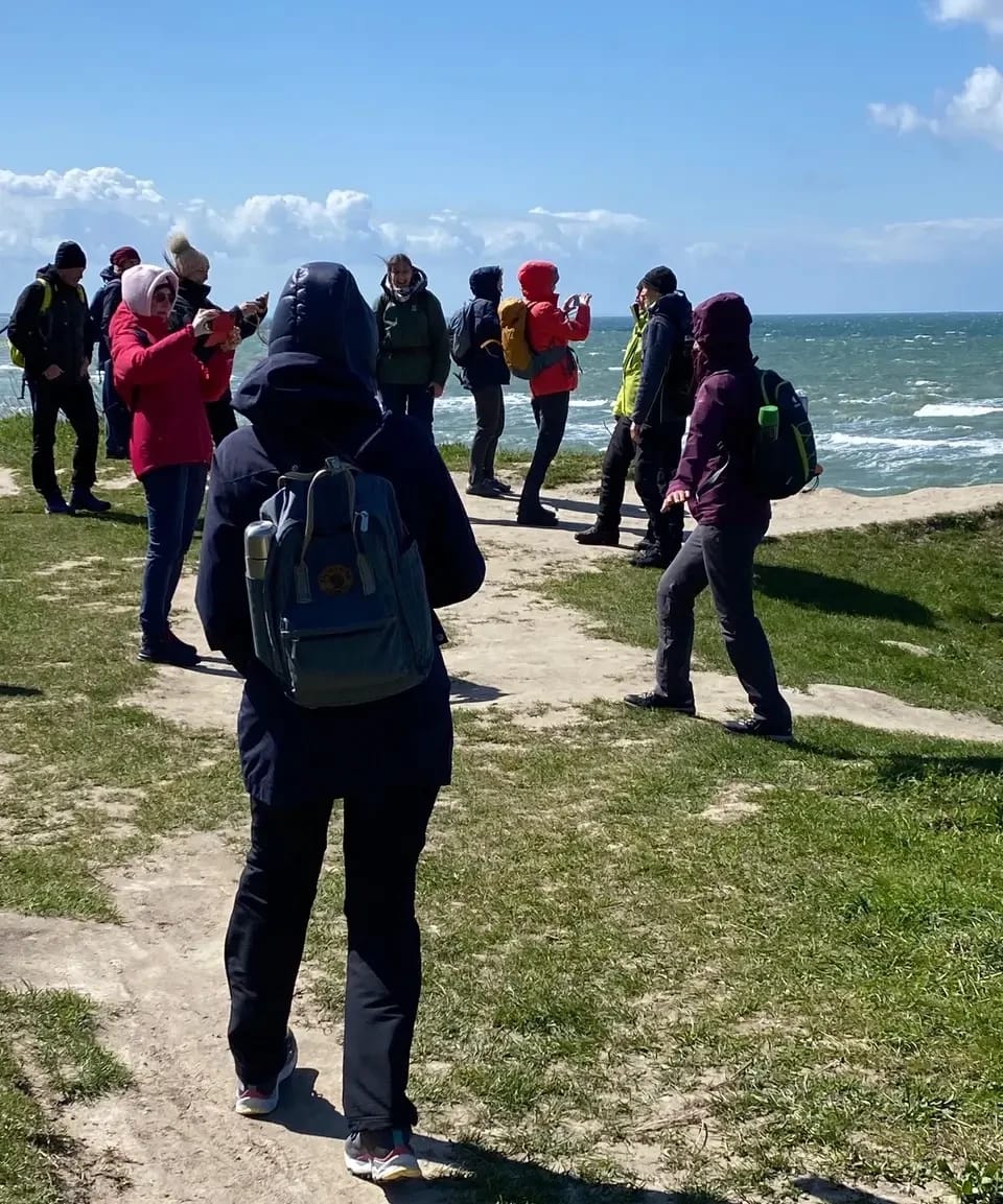 Wandergruppe beim Fotografieren an einer Steilküste