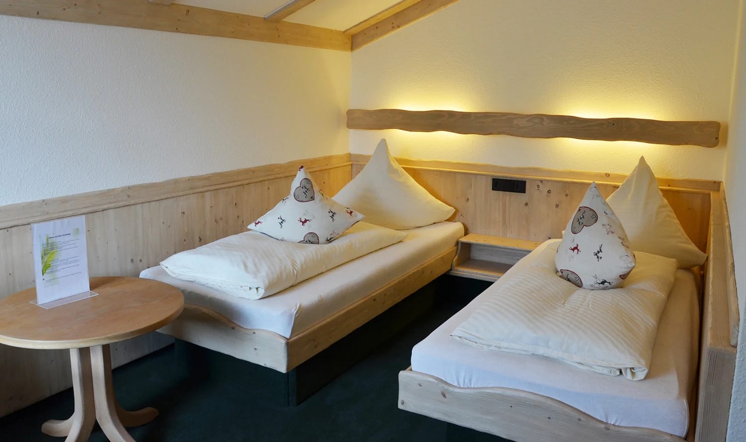 Zimmer mit zwei Einzelbetten und heller Holzvertäfelung