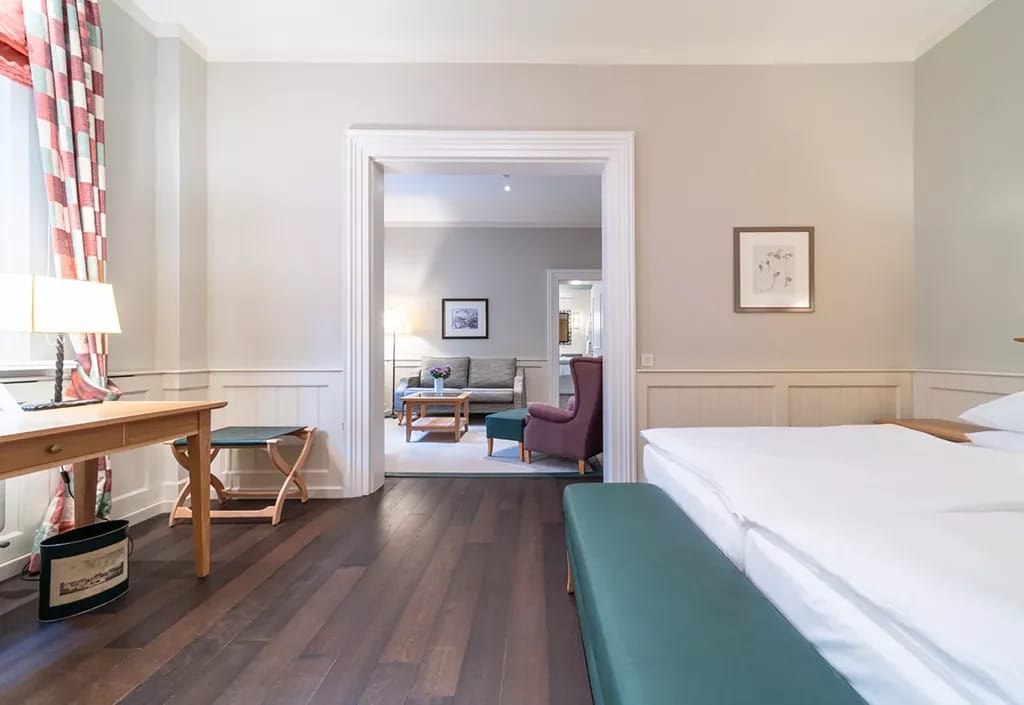 Suite mit Doppelbett, Schreibtisch und angrenzendem Wohnraum mit Sofa
