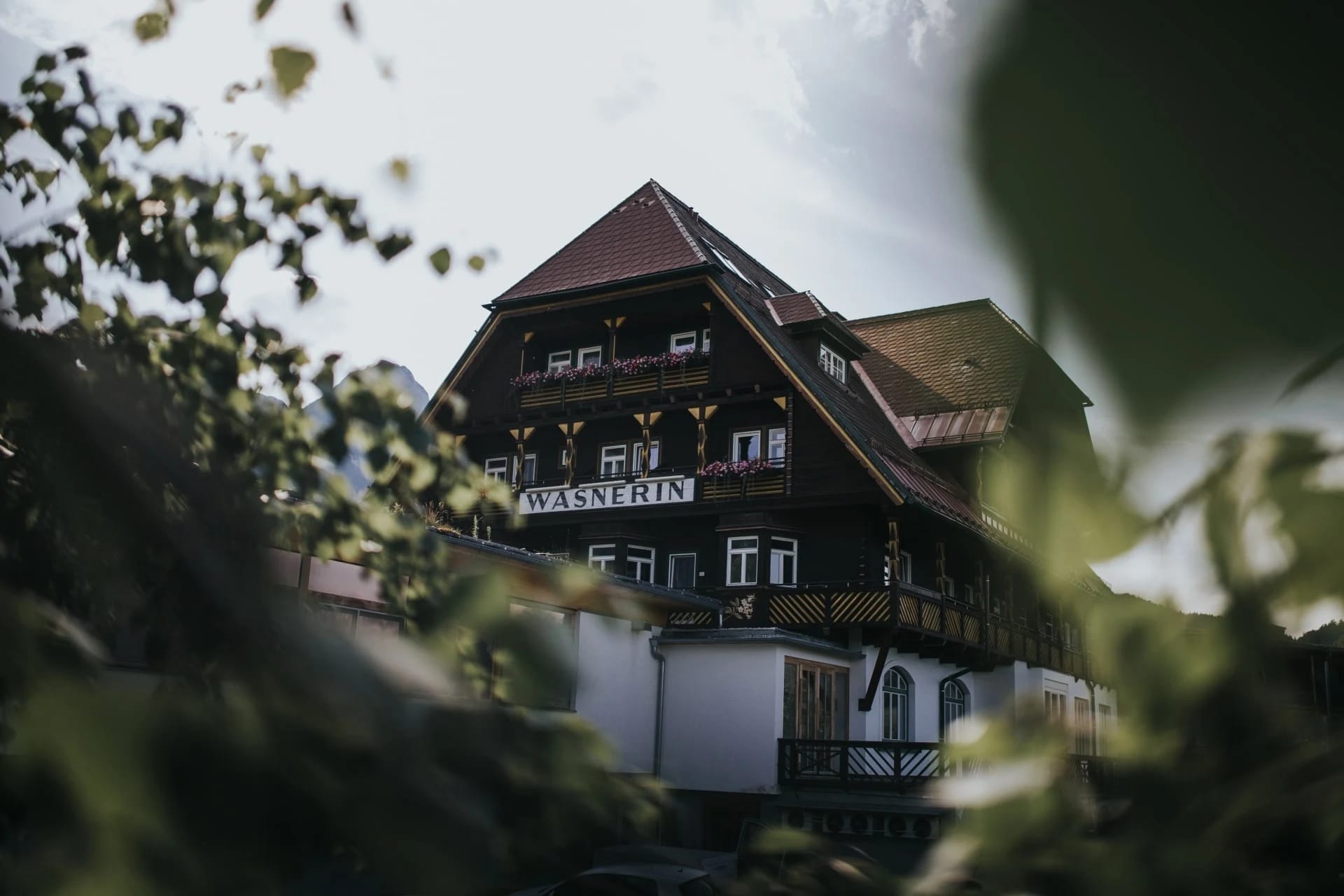 Außenansicht des Stammhauses der Wasnerin mit Holzfassade und Hotelschild
