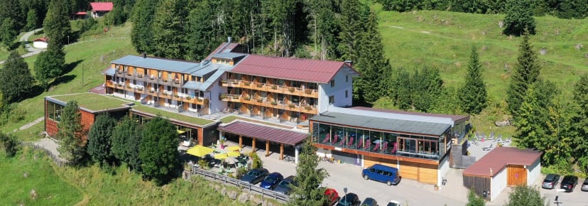 Luftaufnahme des Berghotel Ifenblick im grünen Allgäuer Bergtal mit umliegendem Wald